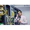 young business man computer science engeneer talking by cellphone at network datacenter server room asking  for help and fast solutions and services