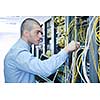 young engeneer business man with thin modern aluminium laptop in network server room