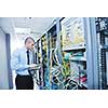 young engeneer business man with thin modern aluminium laptop in network server room