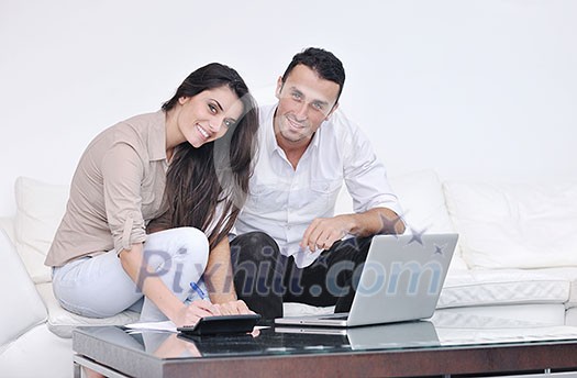 joyful couple relax and work on laptop computer at modern living room indoor home