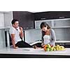 happy young couple have fun in  modern kitchen indoor  while preparing fresh fruits and vegetables food salad