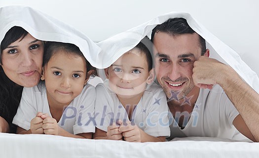 happy young Family in their bedroom have fun and play in bed happy young Family in their bedroom have fun and play in bed