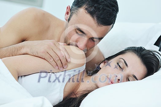 happy young healthy people  couple have good time in their bedroom make love and sleep