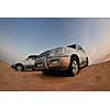 Desert Safari - Off-road jeep vehicles driving in the Arabian Desert at sunset
