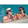 happy young couple relax and take fresh drink at summer vacation on swimmin pool