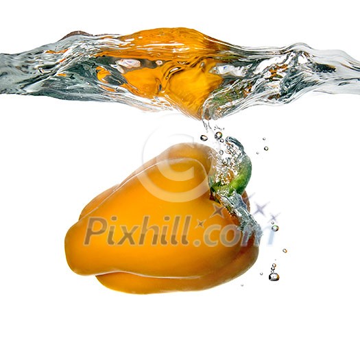 Yellow pepper dropped into water with bubbles isolated on white