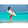 happy young beautiful asian woman relax on sand at tropical beach with cristal clear sea in background