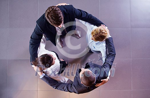 business people group joining hands and representing concept of friendship and teamwork, low angle view business people group joining hands and representing concept of friendship and teamwork, low angle view