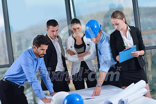 business people group on meeting and presentation in bright modern office with construction engineer architect and worker looking building model and blueprint plans business people group on meeting and presentation in bright modern office with construction engineer architect and worker looking building model and blueprint plans