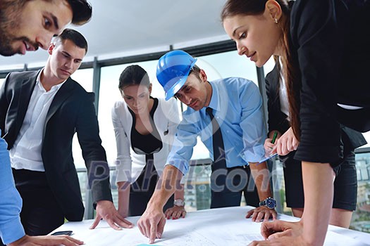 business people group on meeting and presentation in bright modern office with construction engineer architect and worker looking building model and blueprint plans business people group on meeting and presentation in bright modern office with construction engineer architect and worker looking building model and blueprint plans