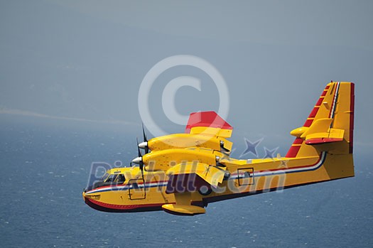 Airplane on sea taking water to drop over fire