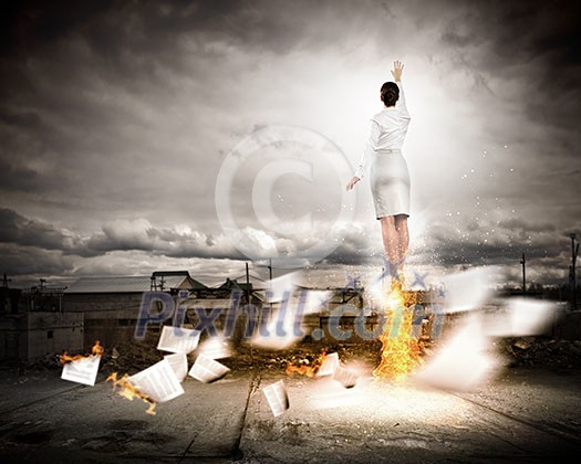 Image of businesswoman flying up into sky