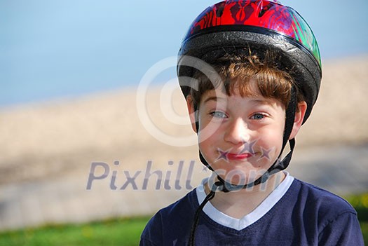 Portrait of a cute little boy in bicycle helmet making silly faces
