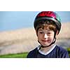 Portrait of a cute little boy in bicycle helmet making silly faces