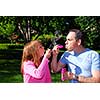 Happy family blowing soap bubbles, father and child