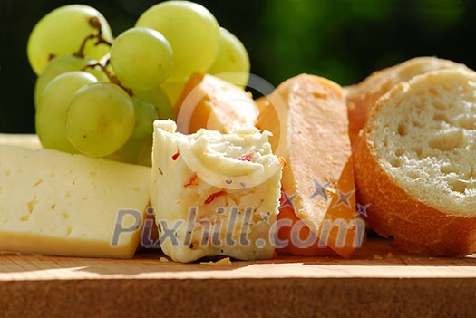 Assorted cheeses with grapes and white bread