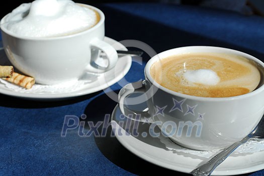 Cappuccino and Latte in cups with saucers Cappuccino and Latte in cups with saucers