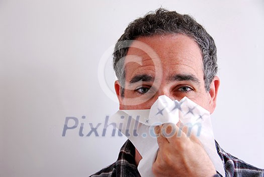 Man with a flu blowing his nose