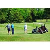 Three senior men on golf course with a golf cart