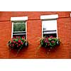 Fragment of a red brick house in Boston historical North End with wrought iron flower boxes