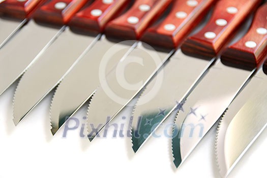 Steak knives in a row on white background Steak knives in a row on white background