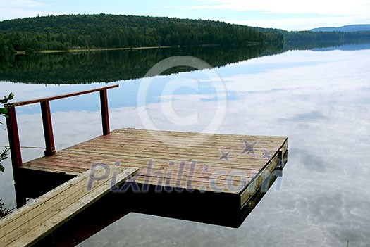 Old wooden boat dock on a beautiful lake in the evening Old wooden boat dock on a beautiful lake in the evening