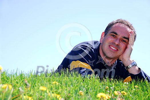 Smiling man on resting on grass