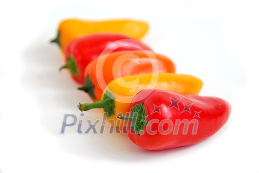 Colorful peppers aligned in perspective on white background Colorful peppers aligned in perspective on white background