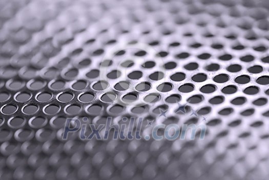 Abstract background of perforated metal with very shallow dof