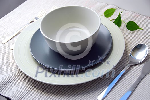 Dinner place setting with plates and soup bowl Dinner place setting with plates and soup bowl