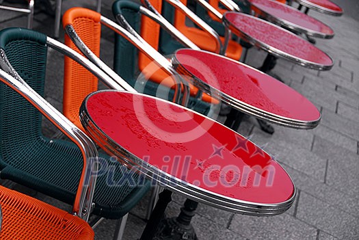 Bright colorful tables in a sidewalk cafe on a rainy day Bright colorful tables in a sidewalk cafe on a rainy day