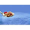 Spoon of cereal on blue background