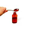 Cough syrup in a spoon and a bottle; shallow depth of field, focus is on top of the bottle