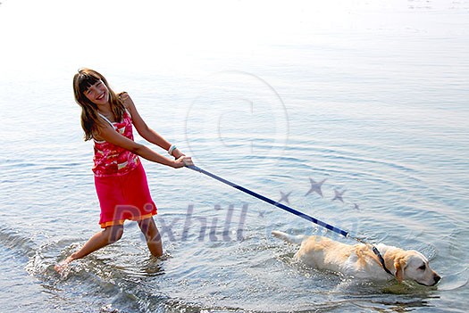 Happy girl playing with her dog in water Happy girl playing with her dog in water