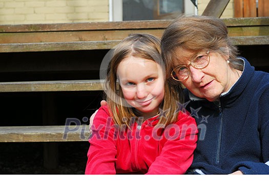 Grandmother and granddaughter sitting on a deck