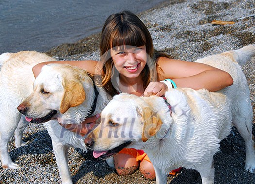 Portrait of a young pretty girl with two dogs on a beach Portrait of a young pretty girl with two dogs on a beach