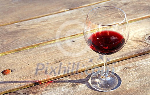 Glass of red wine on old rustic table Glass of red wine on old rustic table