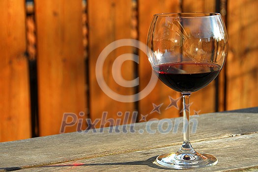Glass of red wine on old rustic table, horisontal