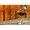 Glass of red wine on old rustic table, horisontal