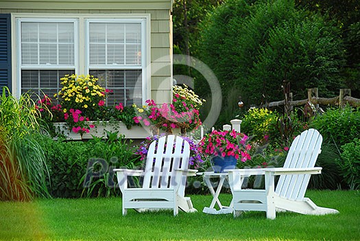 Two lawn chairs in a beautifl garden