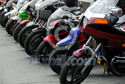 Row of motocycles parked on a street in front a motorcycle store Row of motocycles parked on a street in front a motorcycle store