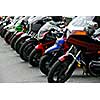 Row of motocycles parked on a street in front a motorcycle store