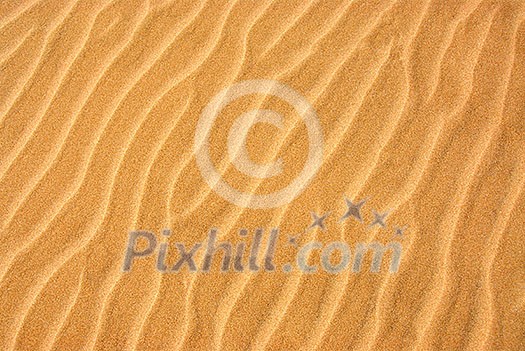 Background of a beautiful pattern on a yellow sand Background of a beautiful pattern on a yellow sand