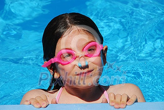 Portrait of a smiling girl in pink goggles in a swimming pool Portrait of a smiling girl in pink goggles in a swimming pool