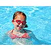 Young girl in red goggles in swimming pool