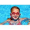 Young girl in red goggles in a swimming pool