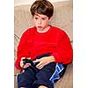 Young boy playing a video game sitting on a couch
