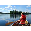 Young girl in canoe paddling on a scenic lake