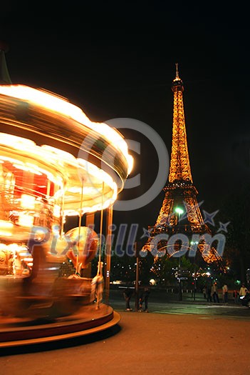 Spinning traditional carousel in Paris France at night with Eiffel tower in the background Spinning traditional carousel in Paris France at night with Eiffel tower in the background