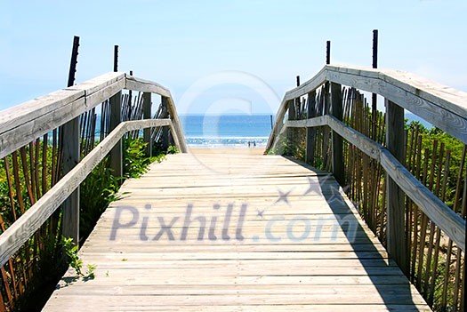 Wooden path over sand dunes with ocean view